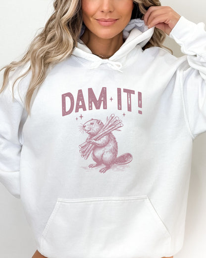 Woman wearing a white 'Dam It' hoodie with a funny retro beaver graphic.