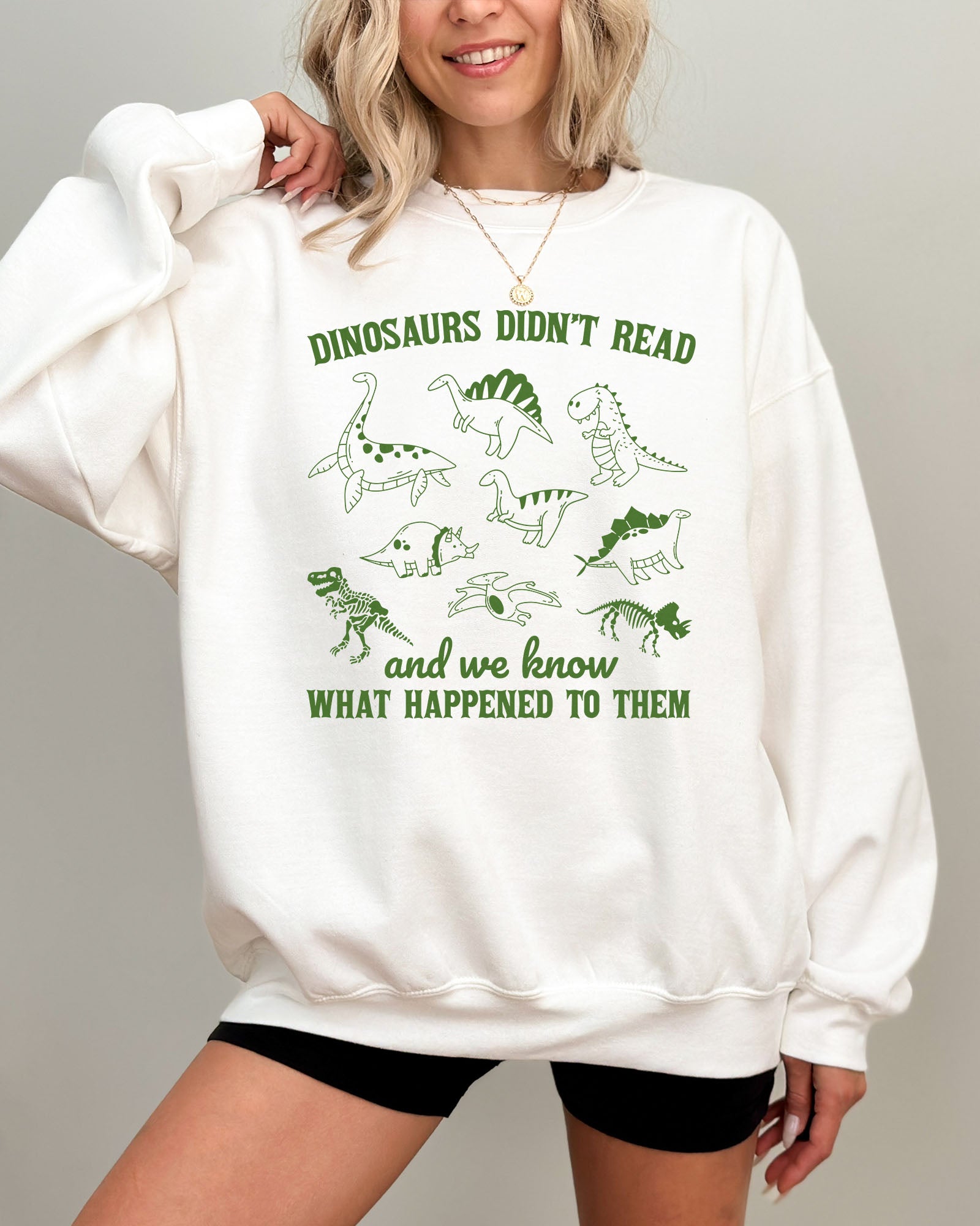 Model wearing white color sweatshirt with 'Dinosaurs Didn't Read And We Know What Happened To Them' graphic design