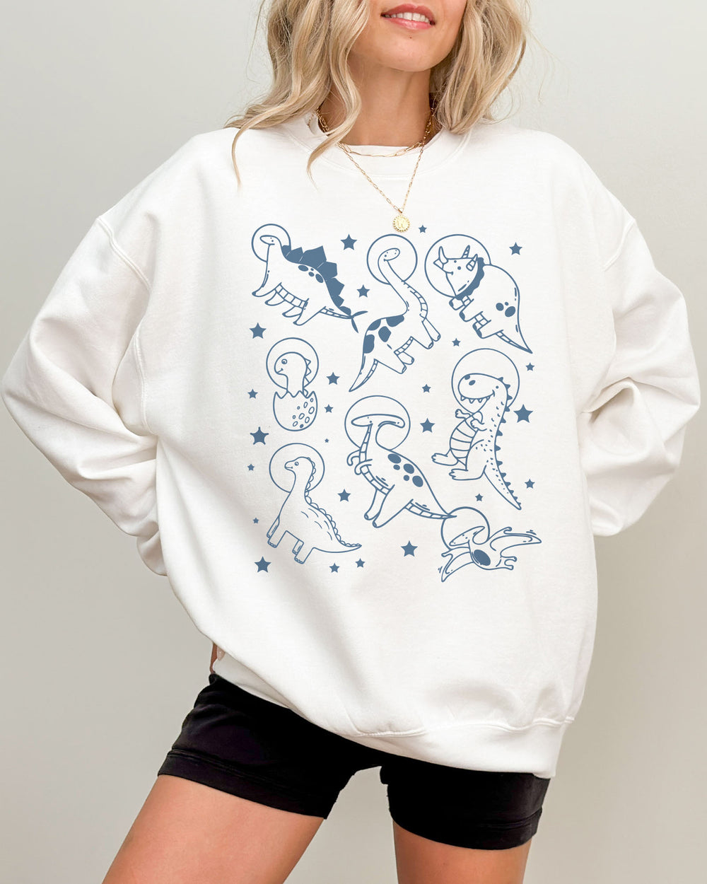 Model wearing white color sweatshirt with 'Dinosaurs In Space' graphic design