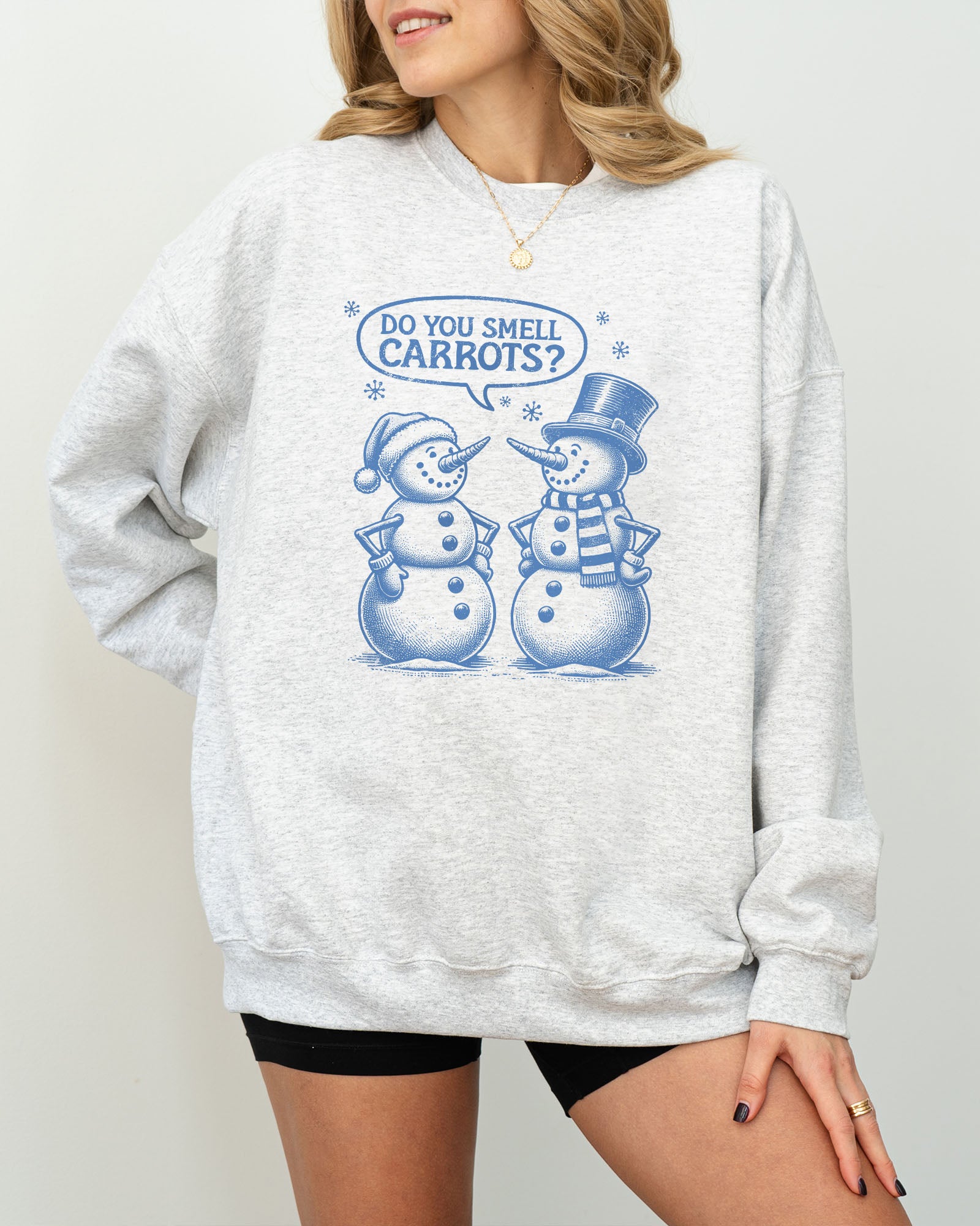 Model wearing ash color sweatshirt with 'Do You Smell carrots?' snowmen conversation graphic design