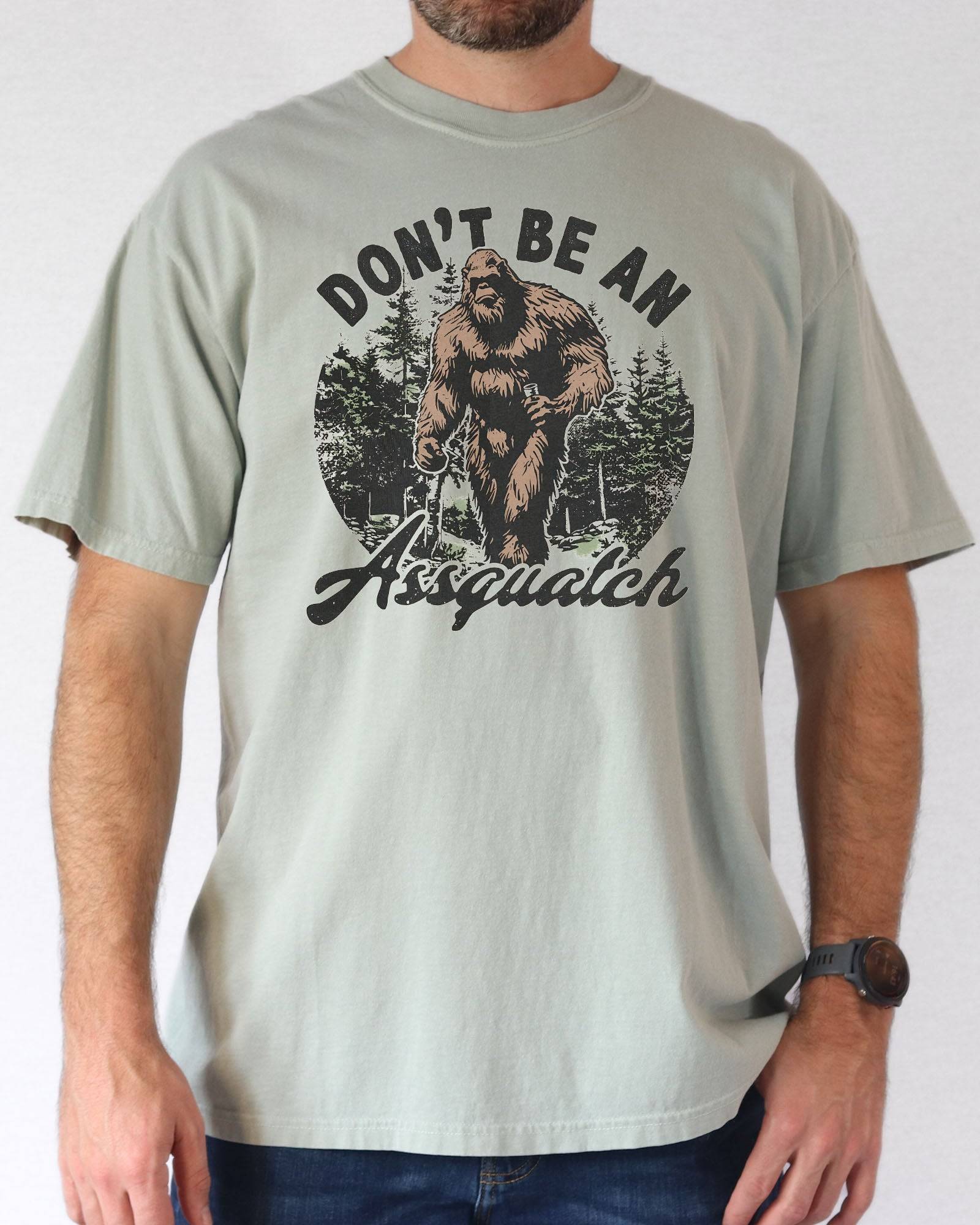 Man wearing a bay "Don't Be an Assquatch" shirt with a funny retro graphic of Bigfoot.