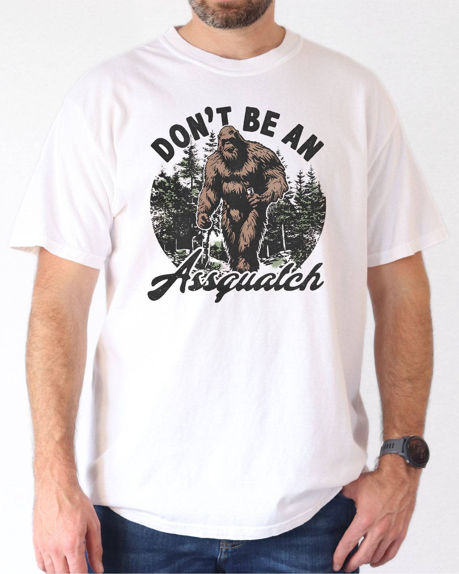 Man wearing a white "Don't Be an Assquatch" shirt with a funny retro graphic of Bigfoot.