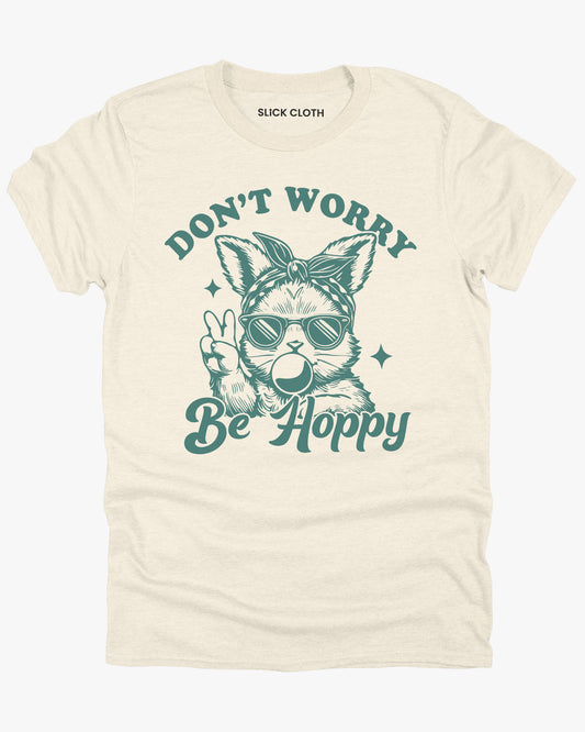 Flat lay natural-colored 'Don't Worry, Be Hoppy' shirt featuring a funny retro easter bunny graphic.