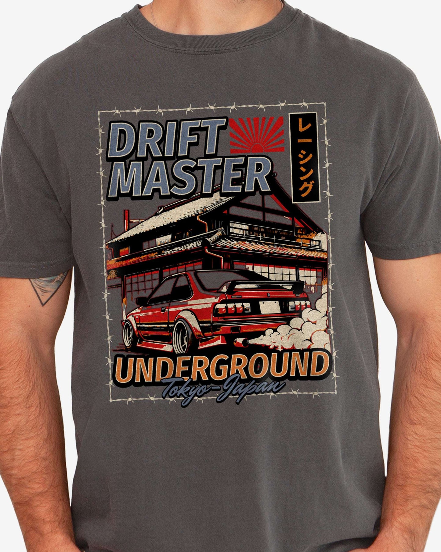 Close-up of man wearing a pepper Drift Master Tokyo shirt with a retro graphic of a race car and Japanese house.