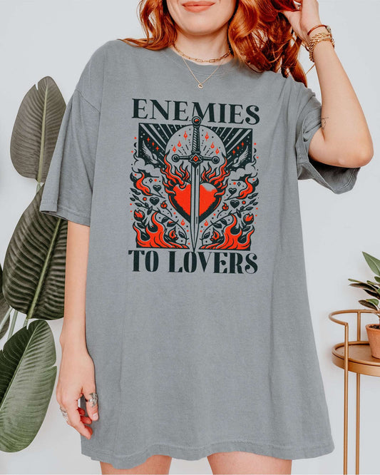 Woman wearing gray color "Enemies To Lovers" shirt with retro medieval romantic graphic.