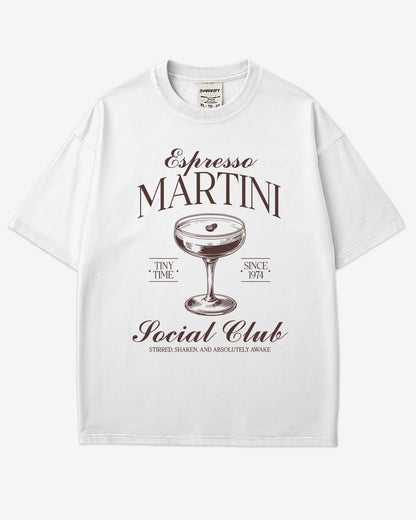 Flat lay white 'Espresso Martini Social Club – Stirred, Shaken, and Awake' shirt with a retro graphic of an espresso martini glass.