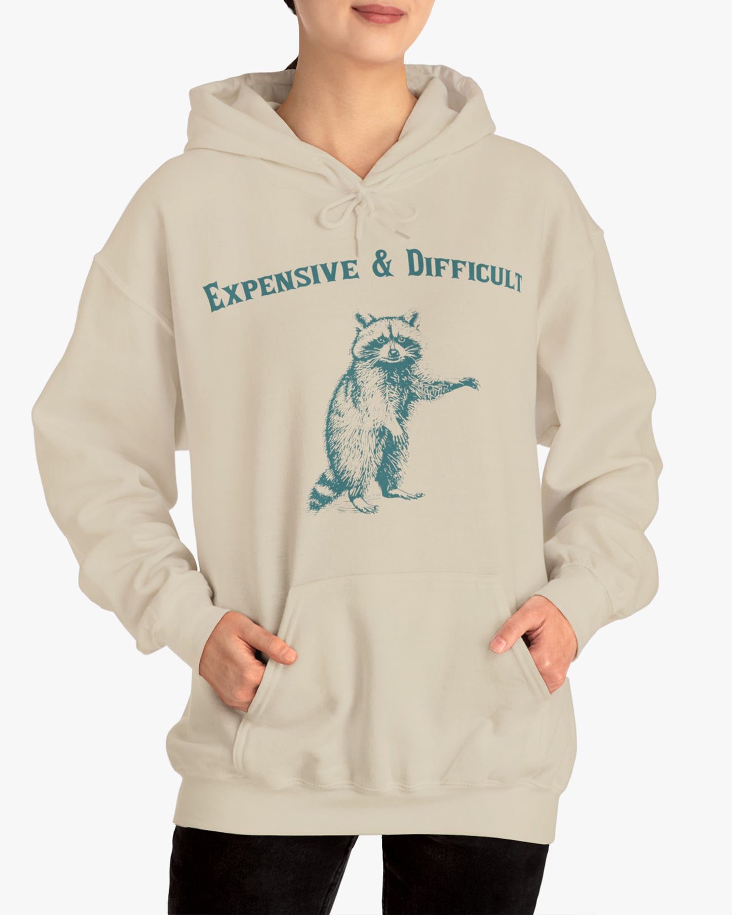 Woman wearing an 'Expensive And Difficult' hoodie in sand beige, featuring a retro western graphic design and unisex fit.