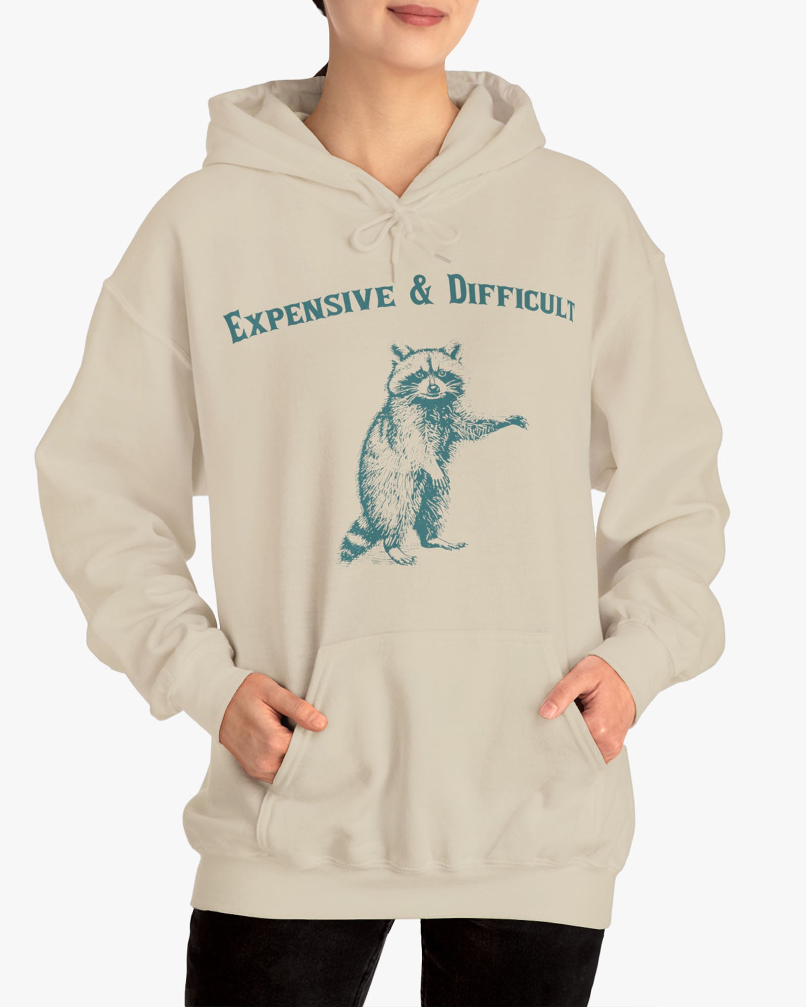 Woman wearing an 'Expensive And Difficult' hoodie in sand beige, featuring a retro western graphic design and unisex fit.