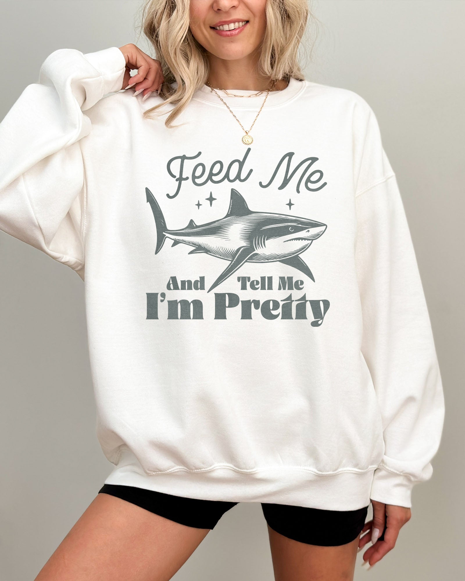 Model wearing white color sweatshirt with 'Feed Me And Tell Me I'm Pretty' graphic design