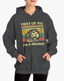 Woman wearing a 'First of All I'm A Delight' hoodie in dark heather, featuring a retro western graphic design and unisex fit.