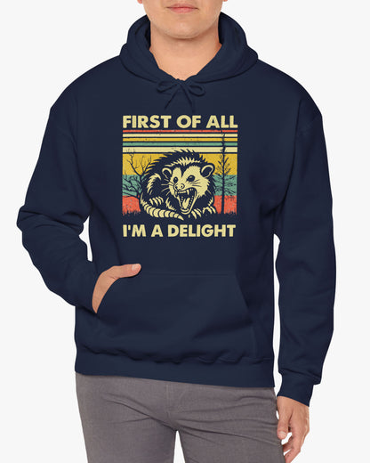 Man wearing a 'First of All I'm A Delight' hoodie in black, featuring a retro western graphic design and unisex fit.