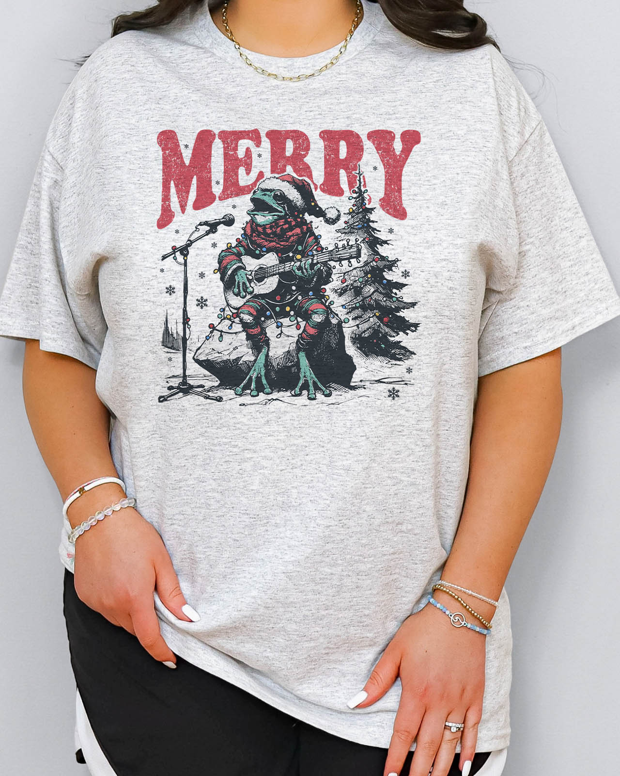 Woman wearing retro Christmas graphic shirt with a funny singing frog graphic