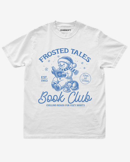 White shirt with cute snowman reading book design and “Frosted Tales Book Club” text