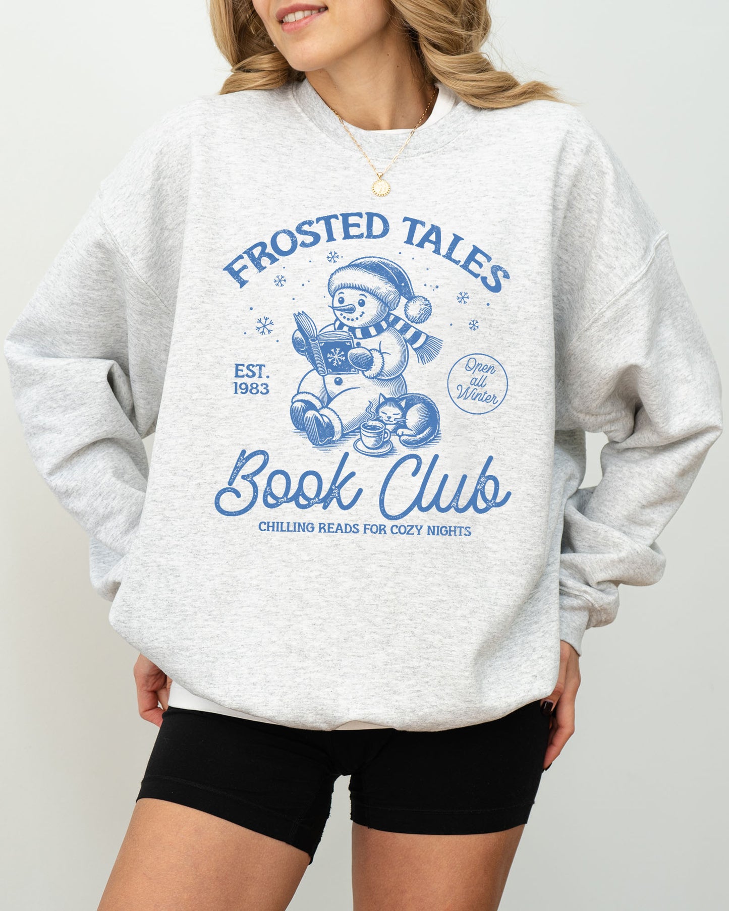Model wearing ash color sweatshirt with 'Frosted Tales Book Club' graphic design