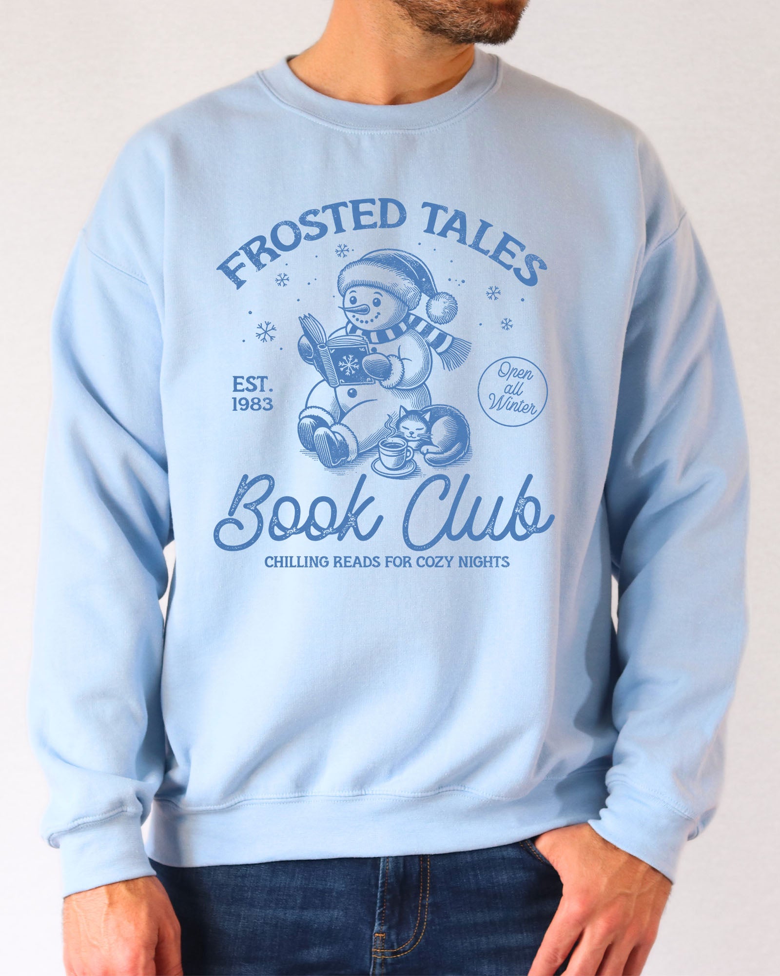 Model wearing light blue color sweatshirt with 'Frosted Tales Book Club' graphic design