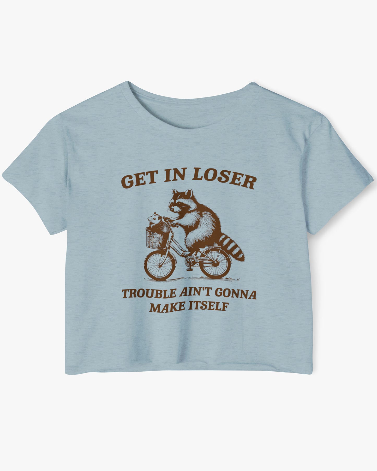 Flat lay stonewash denim 'Get In Loser, Trouble Ain't Gonna Make Itself' crop top featuring a funny retro raccoon riding a bicycle.