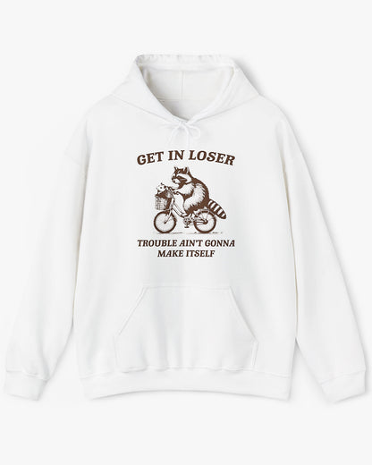 Flat lay white color hoodie with the quote 'Get In Loser, Trouble Ain't Gonna Make Itself' and a funny retro raccoon riding a bycicle graphic