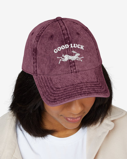 Woman wearing "Good Luck" embroidered vintage cap in maroon with retro graphic of running rabbit