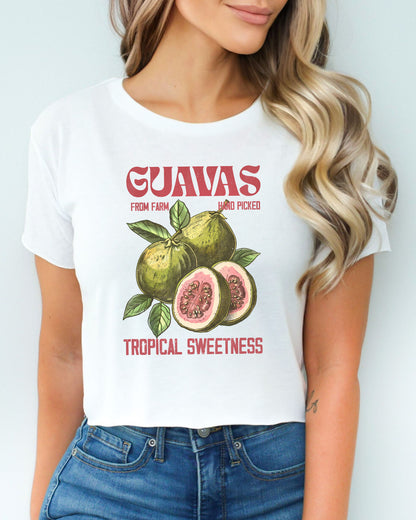 Woman wearing a white crop top with a retro commercial guavas fruit graphic.