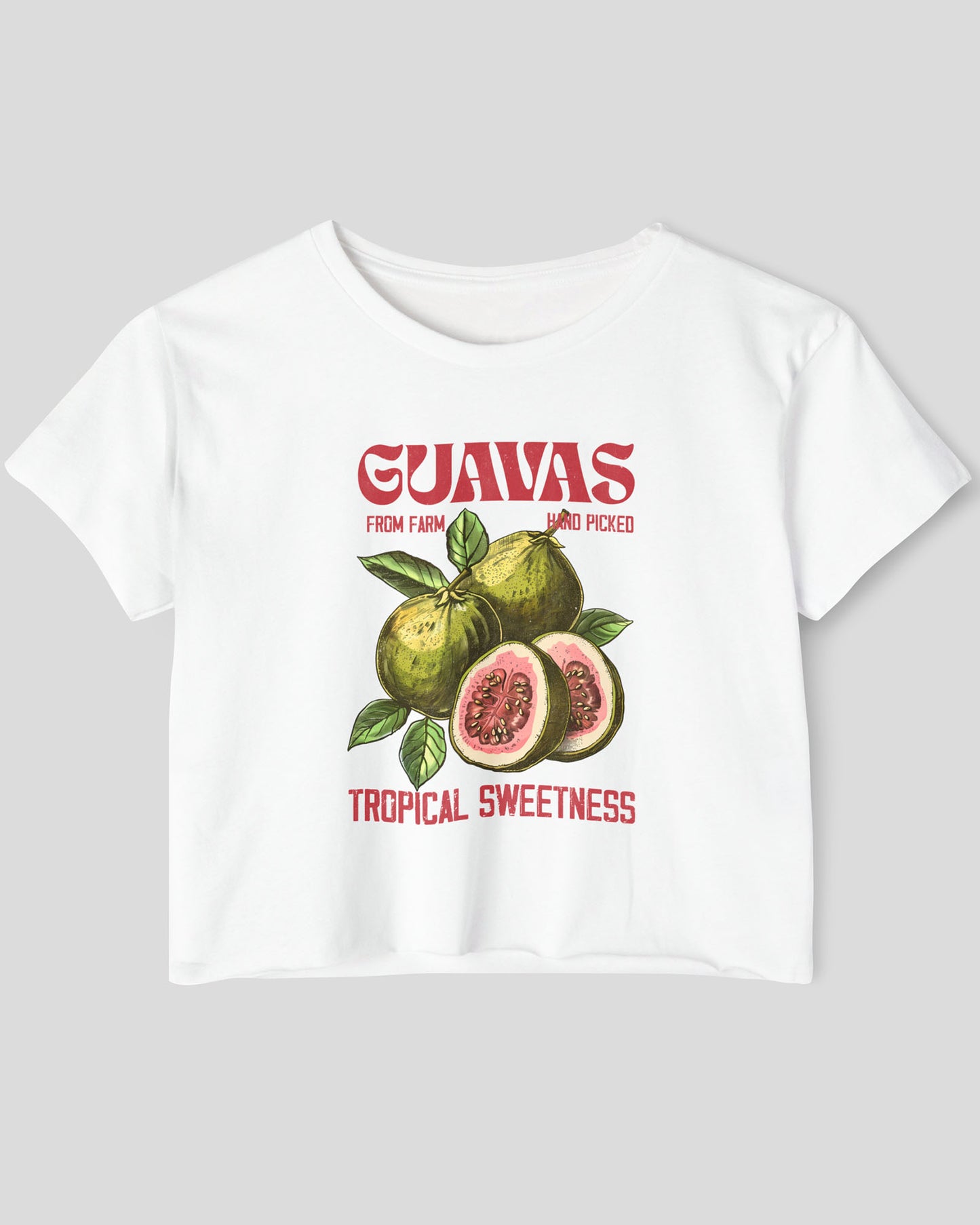 Flat lay of a white crop top with a retro commercial guavas fruit graphic.