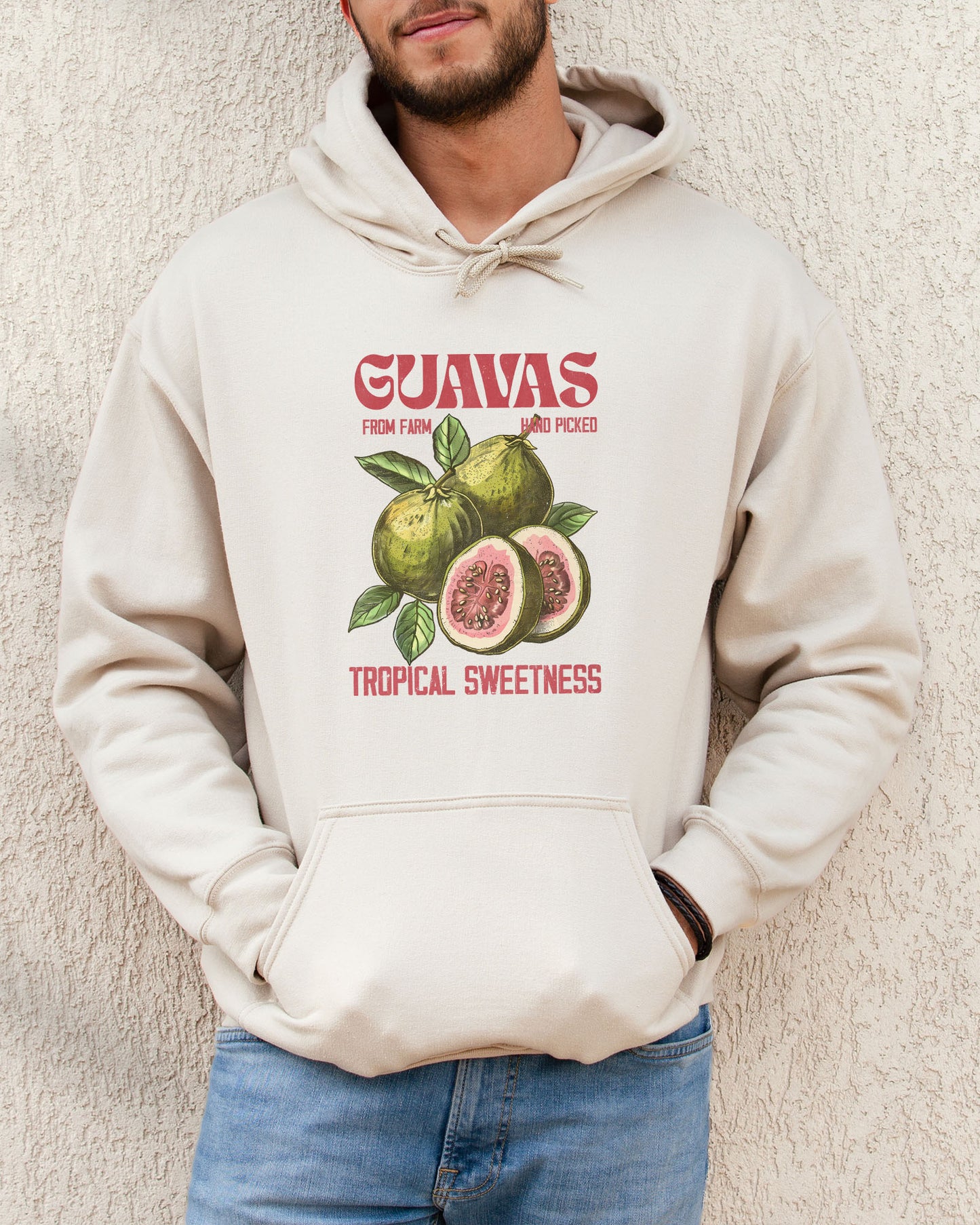 Man wearing a sand beige vintage-style Guavas Fruit Hoodie featuring a retro guava label graphic on a soft, cozy unisex hoodie.