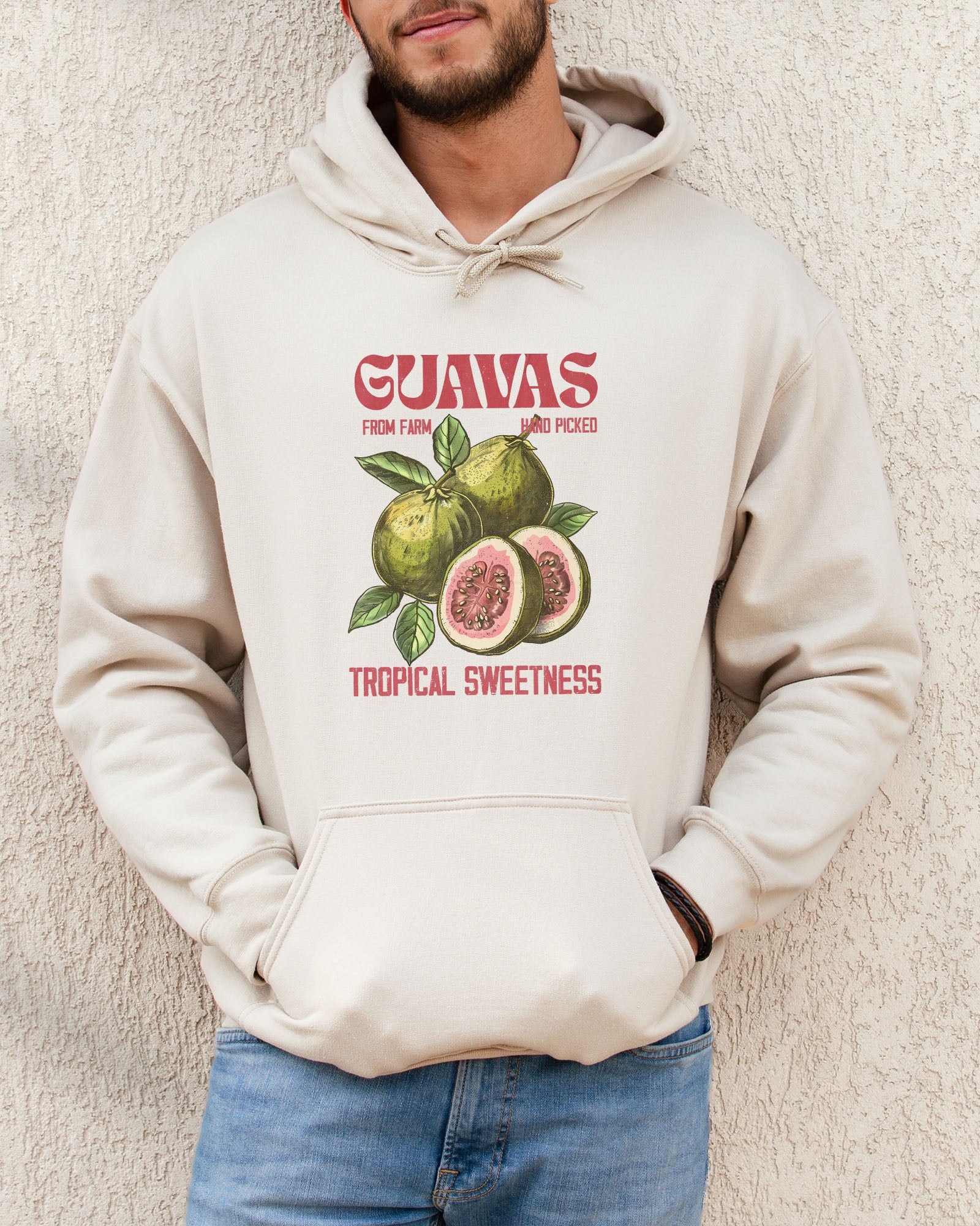 Man wearing a sand beige vintage-style Guavas Fruit Hoodie featuring a retro guava label graphic on a soft, cozy unisex hoodie.