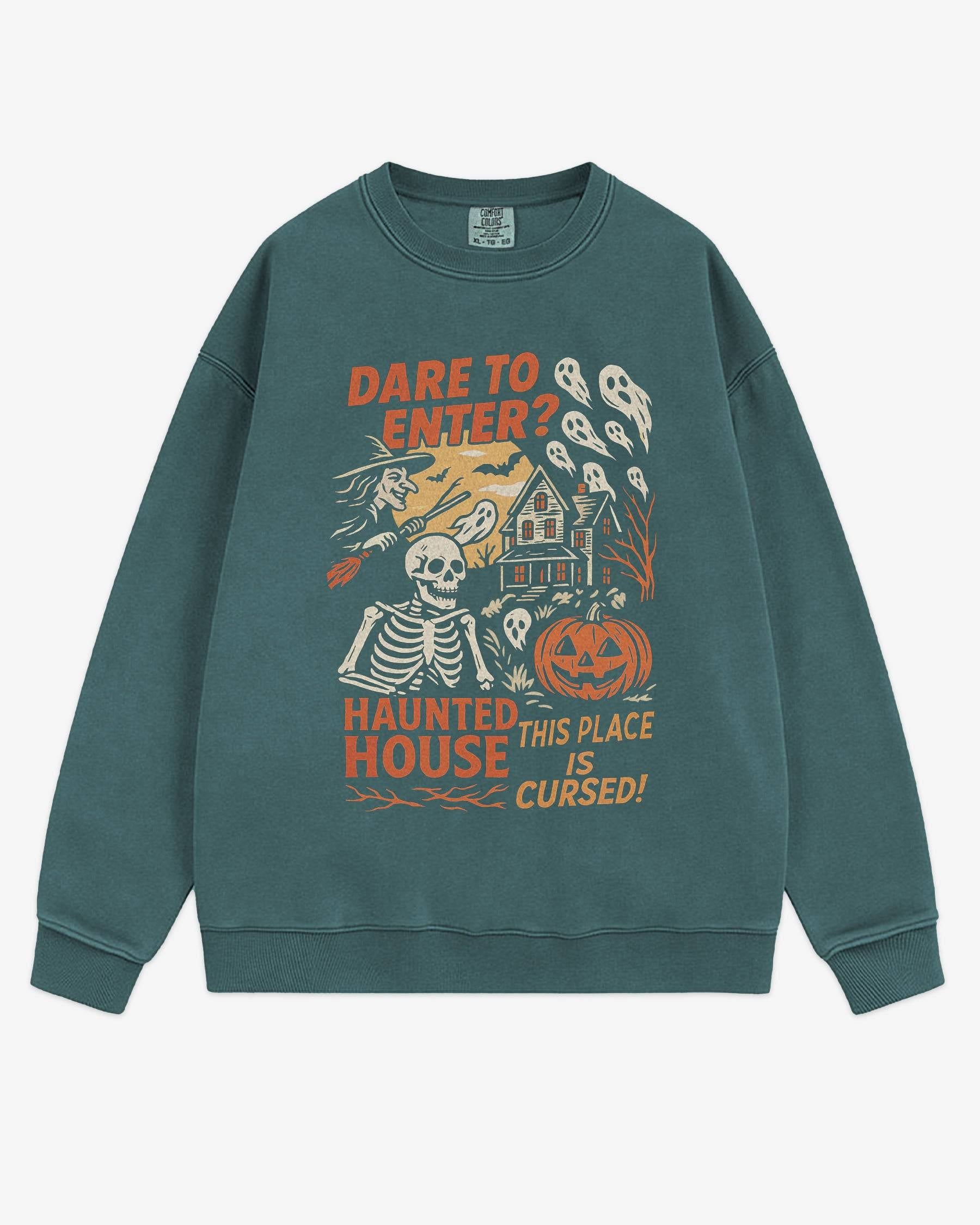 Flat lay blue spruce Halloween sweatshirt reading ‘Dare To Enter – Haunted House’ with retro graphic of haunted house, skeletons, and a witch.