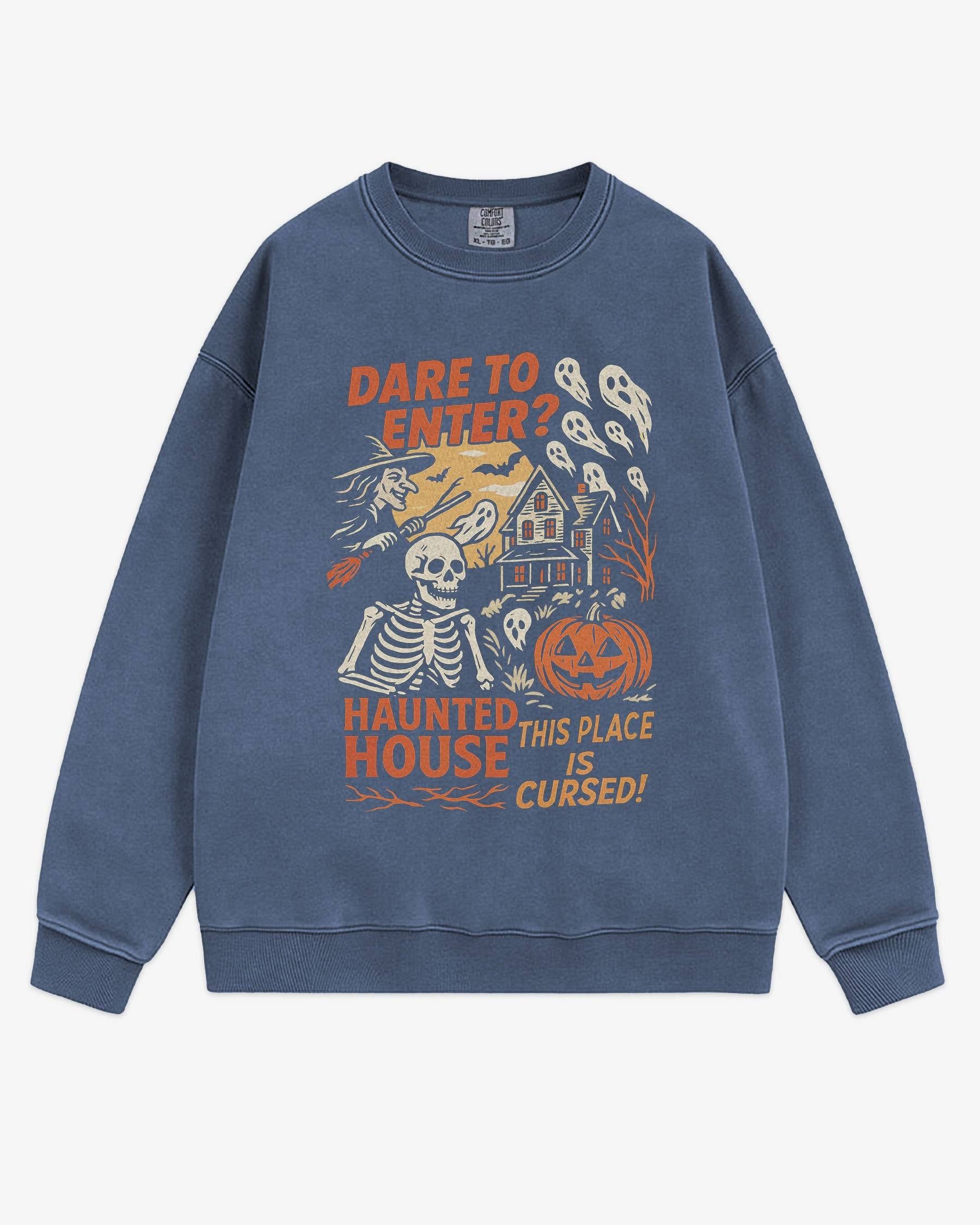 Flat lay denim Halloween sweatshirt reading ‘Dare To Enter – Haunted House’ with retro graphic of haunted house, skeletons, and a witch.