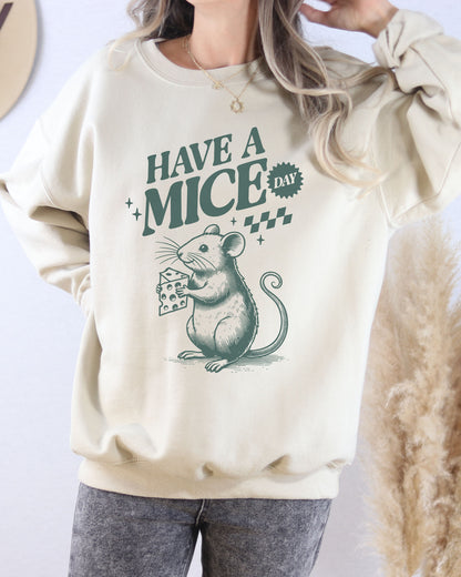 Model wearing sand color sweatshirt with 'Have A Mice Day' graphic design