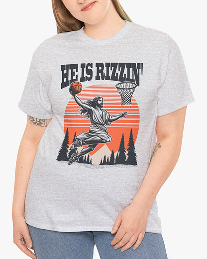 Woman wearing 'He Is Rizzin' tee in ash gray color with Jesus playing basketball graphic
