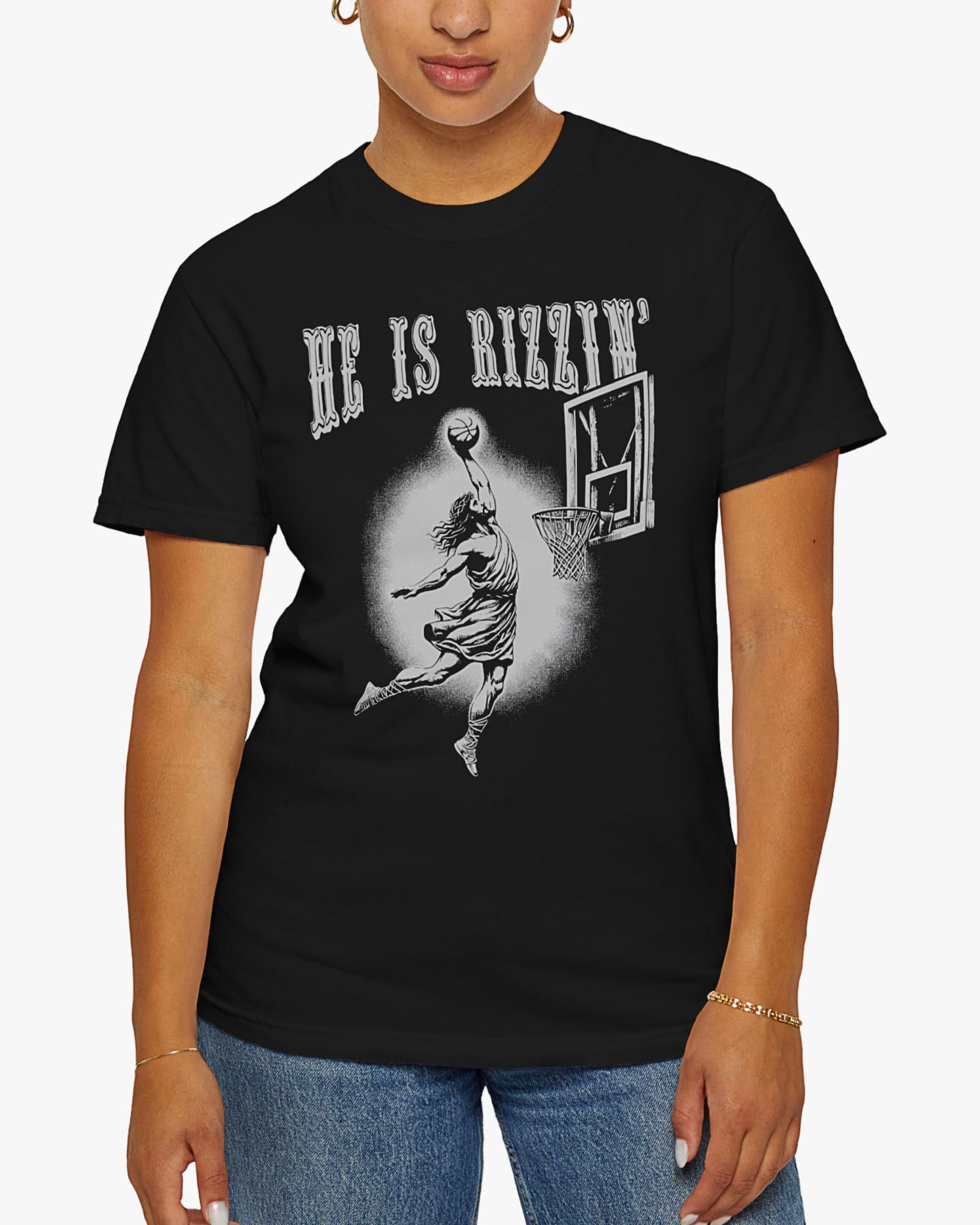 Woman is wearing He is Rizzin' tee in black color with funny Jesus dunking a basketball graphic