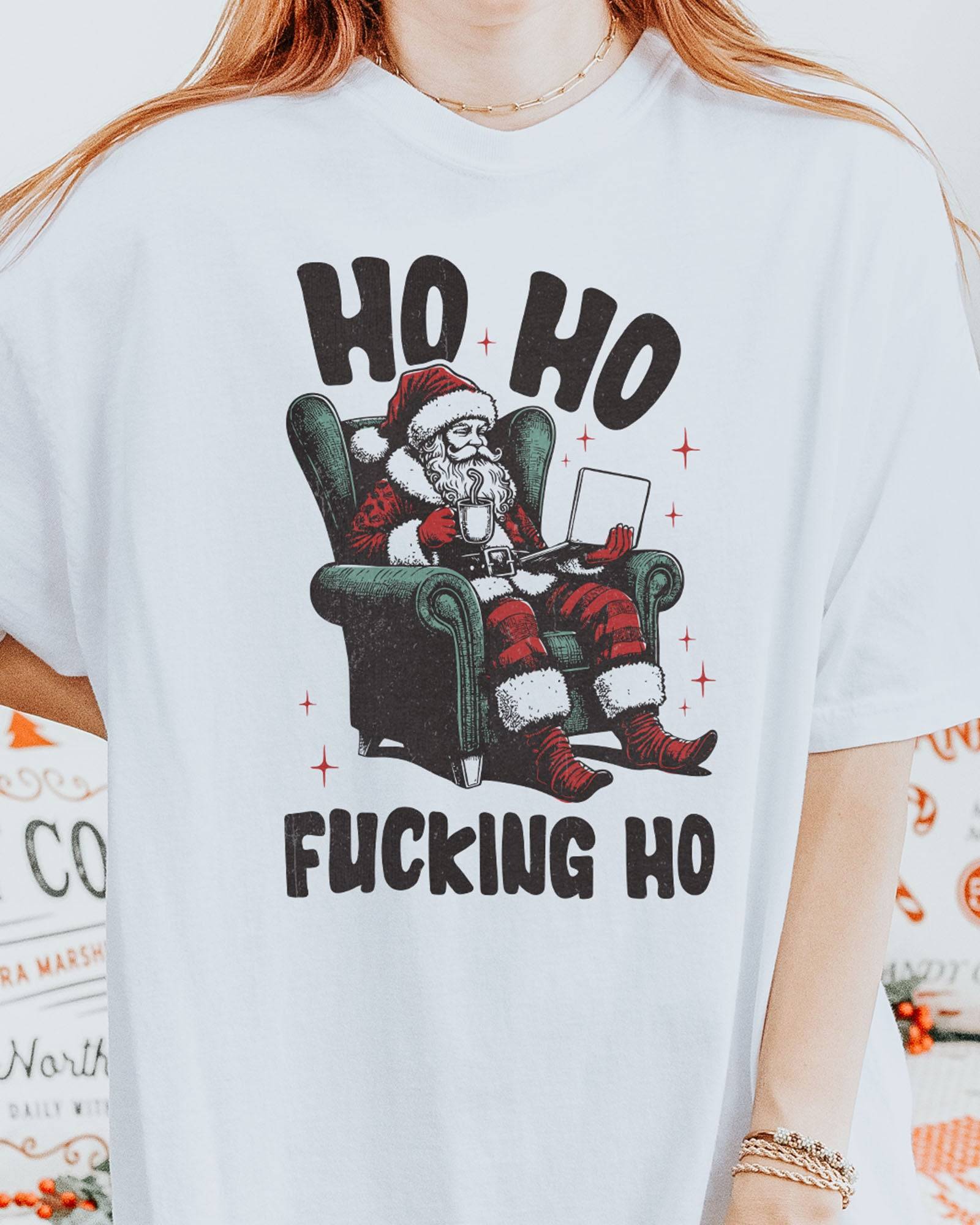 Close-up of woman wearing a white "Ho Ho Fucking Ho" shirt with a funny retro graphic of Santa Claus sitting in an armchair.