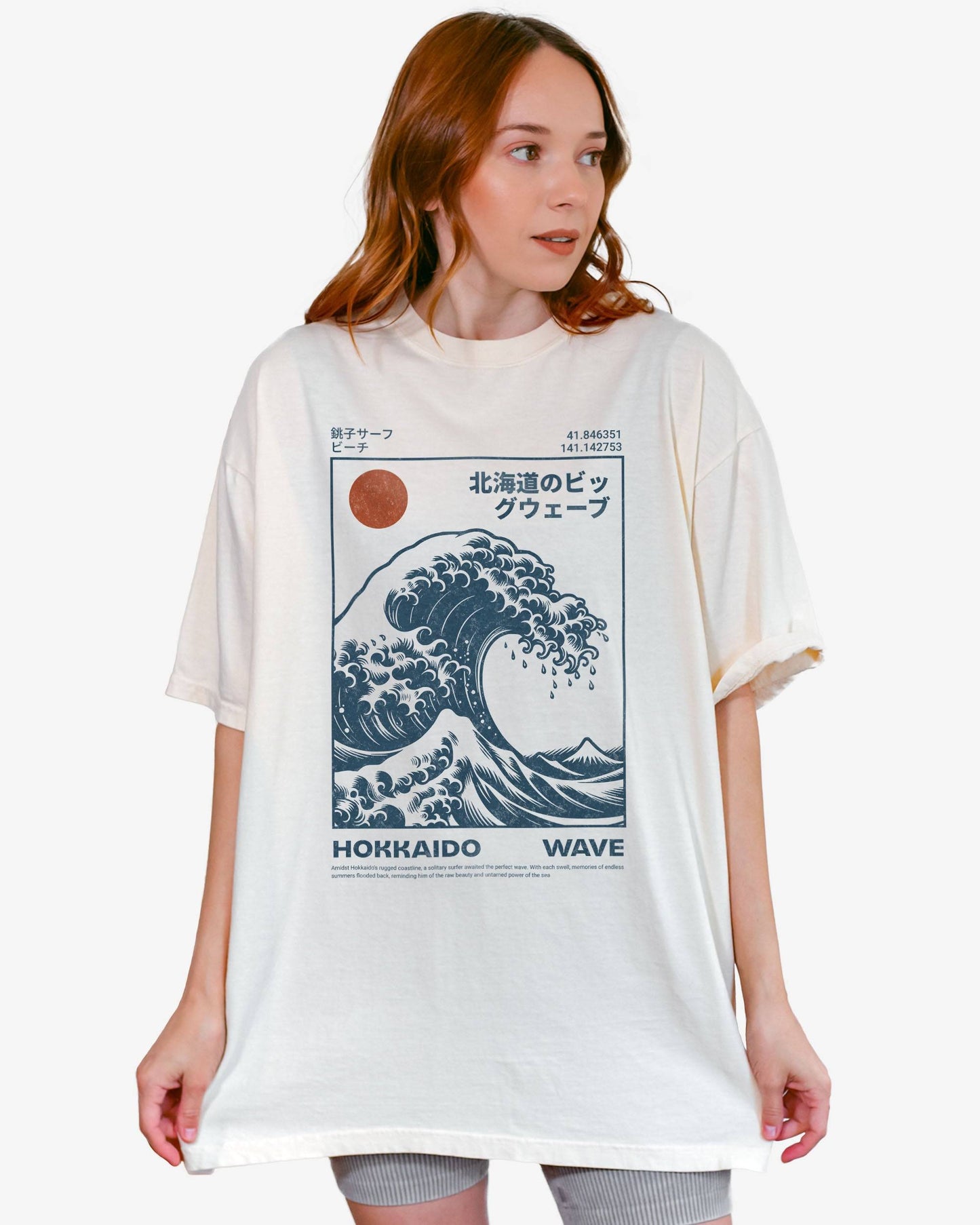Woman wearing an ivory ‘Hokkaido Wave’ surf shirt with a retro Japanese great wave graphic in traditional ukiyo-e style.