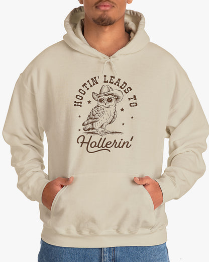 Man wearing sand beige Hootin' Leads To Hollerin' hoodie with funny retro cowboy owl graphic