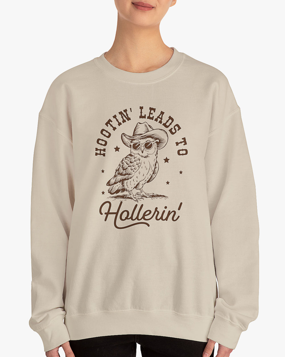 Woman wearing sand beige 'Hootin Leads To Hollerin' sweatshirt with funny retro owl graphic