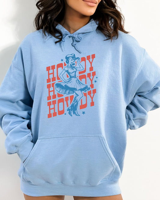 Woman wearing a light blue hoodie with a retro howdy cowgirl graphic.