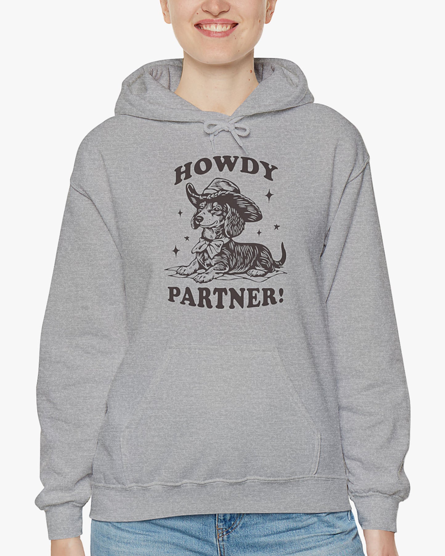 Woman wearing sport gray 'Howdy Partner' hoodie with funny retro cowboy dachshund graphic