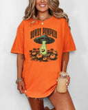Woman wearing a burnt orange "Howdy Pumpkin" shirt with a retro graphic of a UFO abducting pumpkins from a field.
