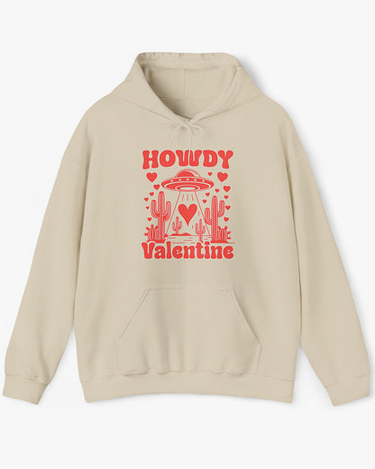 Flat lay sand beige Howdy Valentine hoodie featuring a retro western desert scene with a UFO and floating hearts graphic.