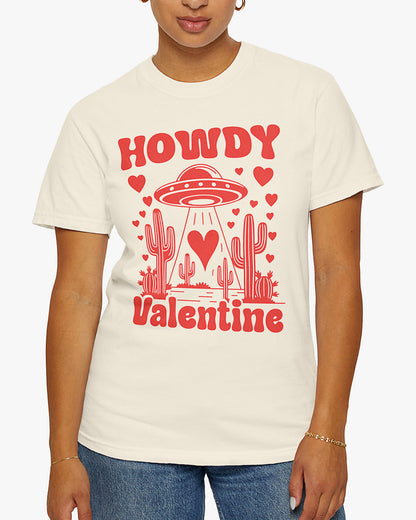 Woman wearing a natural 'Howdy Valentine' shirt featuring a funny retro western landscape graphic with a UFO