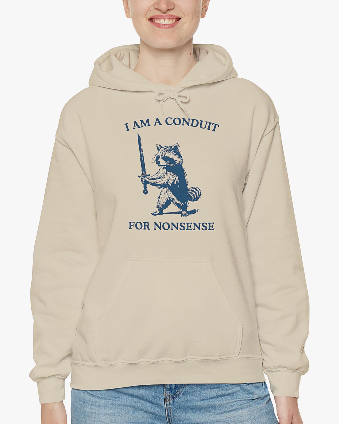 Woman wearing a sand beige 'I Am A Conduit For Nonsense' hoodie with a funny retro raccoon holding a sword graphic