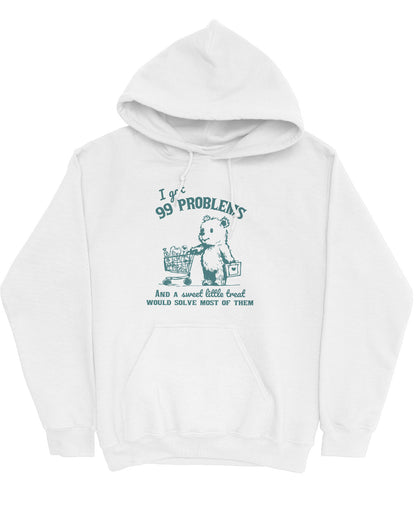 Flat lay of a white hoodie with a cute, funny retro bear pushing a shopping cart and the quote 'I Got 99 Problems But A Sweet Little Treat Is Solving Most Of Them'.