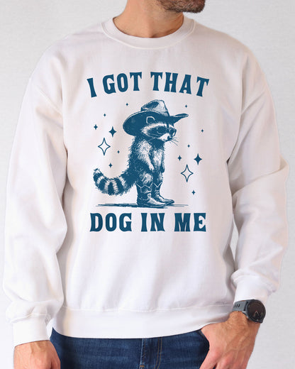 Man wearing a white sweatshirt featuring a funny retro cowboy raccoon graphic and the quote 'I Got That Dog In Me'.