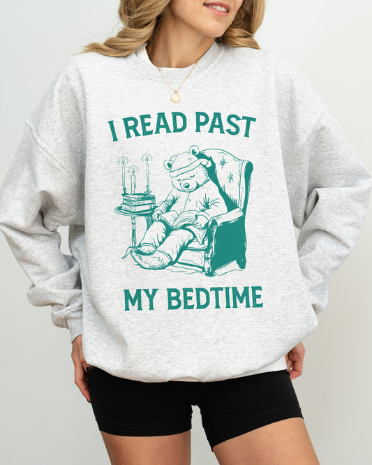 Model wearing ash color sweatshirt with 'I Read Past my Bedtime' graphic design
