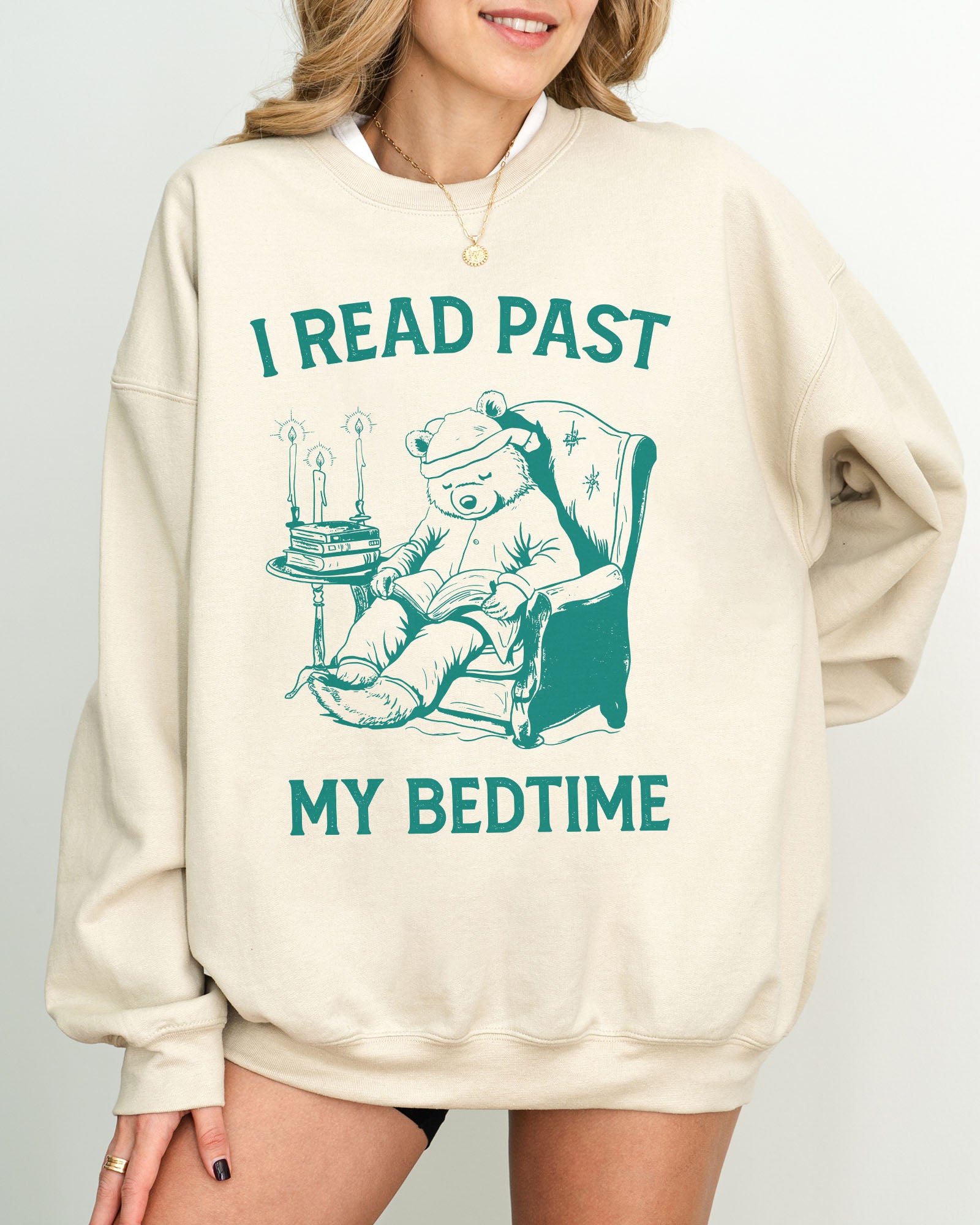 Model wearing sand color sweatshirt with 'I Read Past my Bedtime' graphic design