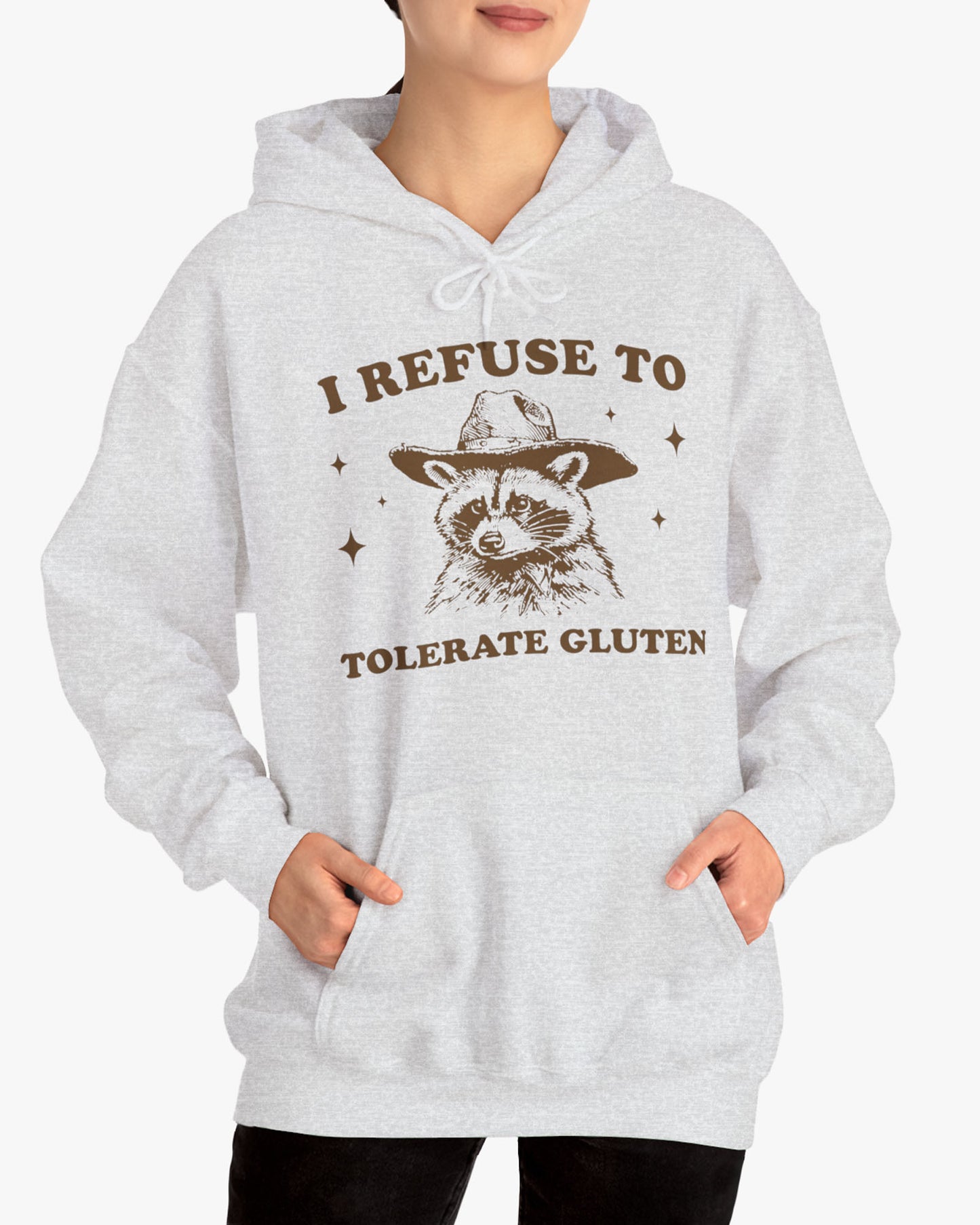 Woman wearing an 'I Refuse To Tolerate Gluten' hoodie in ash gray, featuring a retro western graphic design and unisex fit.