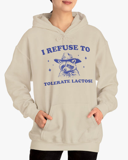 Woman wearing an 'I Refuse To Tolerate Lactose' shirt in sand beige, featuring a retro cowboy raccoon graphic design and unisex fit.