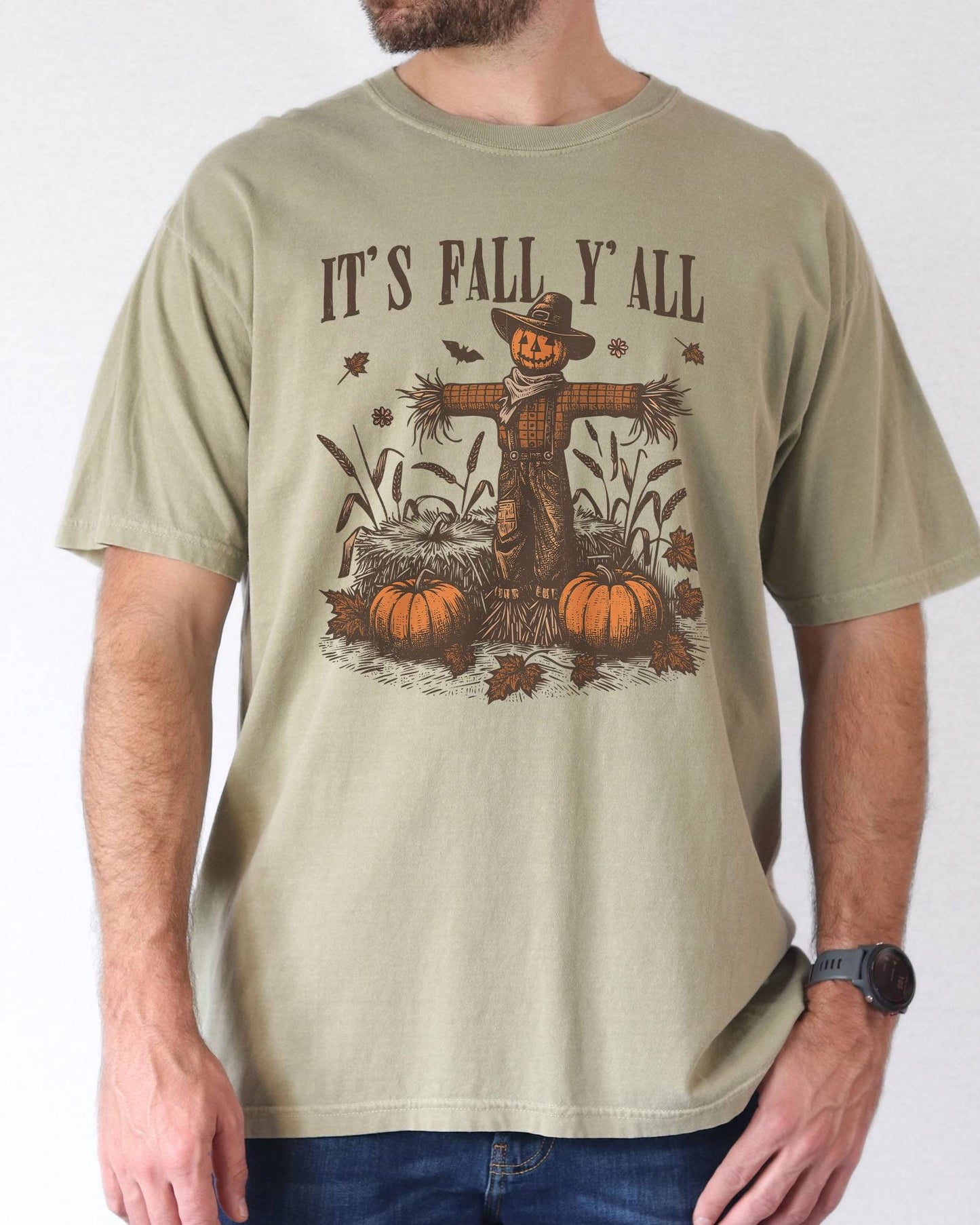 Model wearing khaki color shirt with 'It's Fall Y'all' graphic design