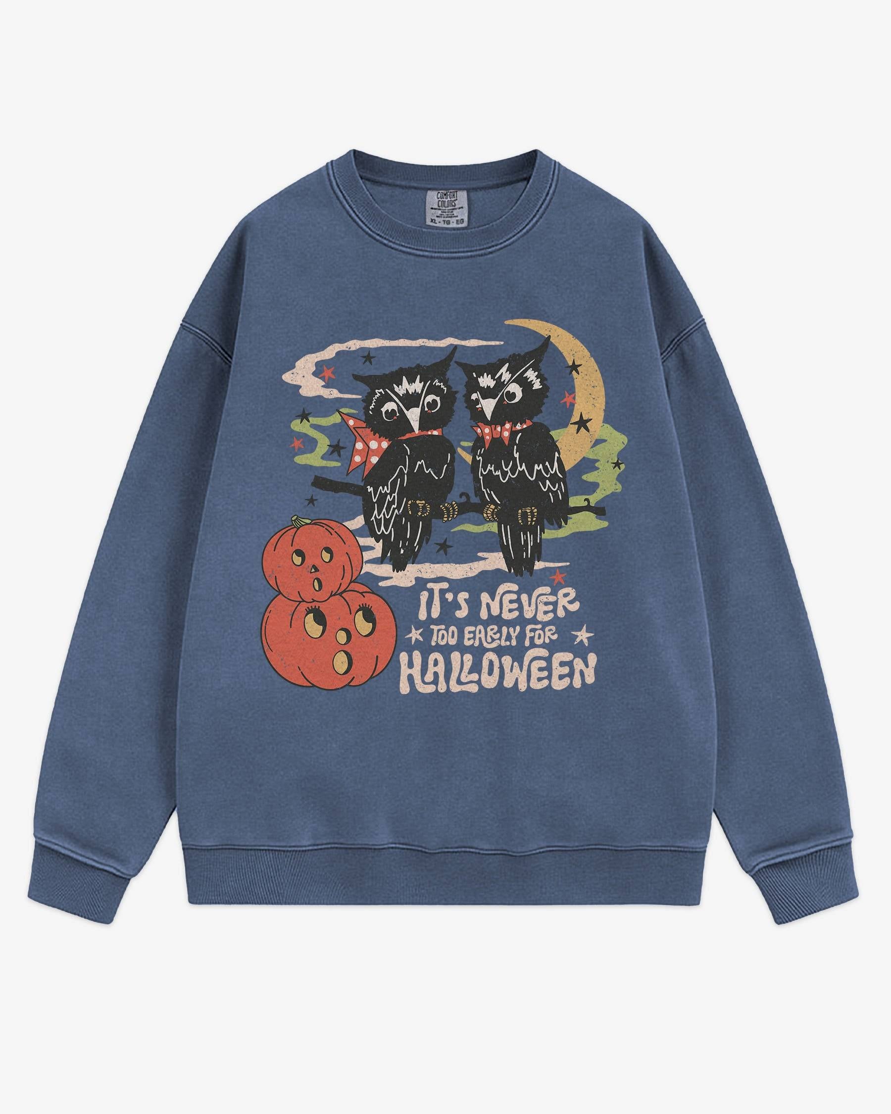 Flat lay denim ‘It’s Never Too Early For Halloween’ sweatshirt with retro graphic of two owls, pumpkins, and night sky.
