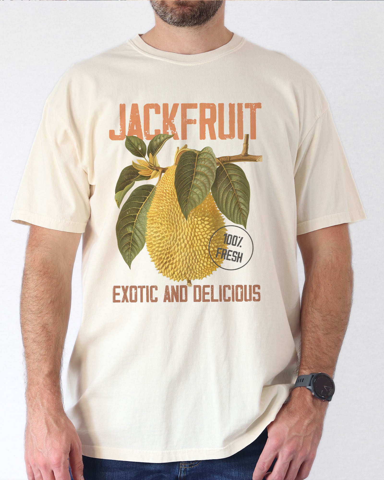 Man wearing a natural-colored Jackfruit t-shirt featuring a retro jackfruit commercial graphic with the quote 'Jackfruit - Exotic and Delicious.'